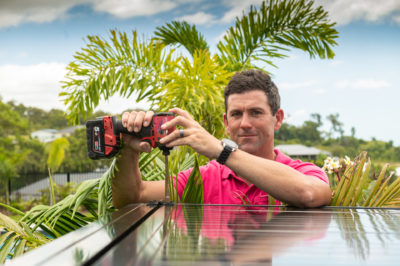 man installing pool pump cover with drill